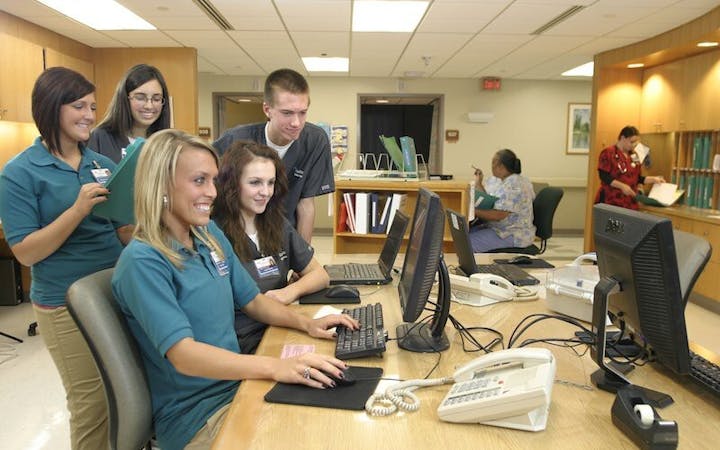 Group of cox health employees surrounding a computer