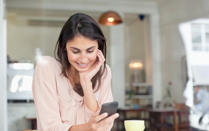 Women looking at her phone in kitchen
