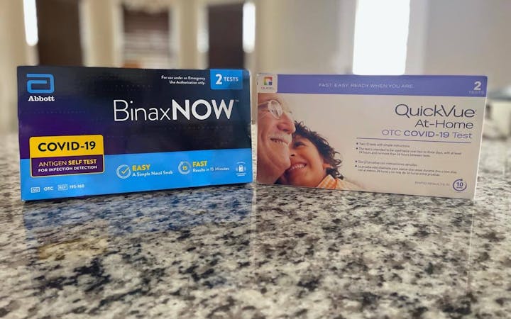 Two COVID-19 at-home tests sitting on a kitchen counter