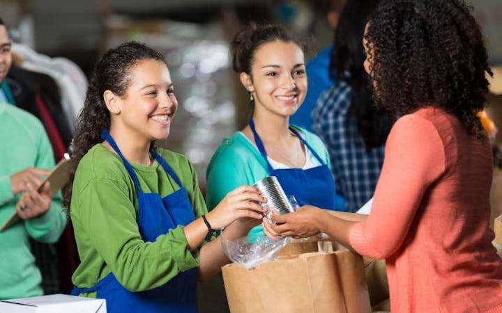 A picture shows women with bags of food.