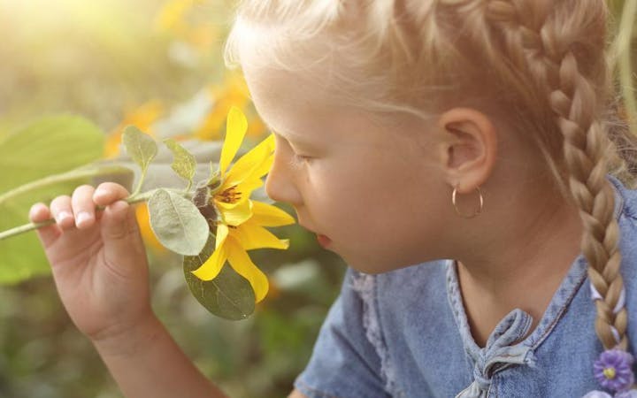 Young girl smelling a flower