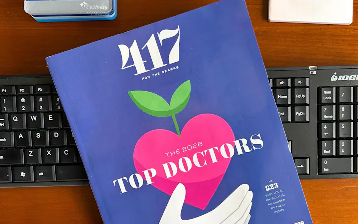 An issue of 417 Top Doctors sits on top a keyboard on someone's desk.