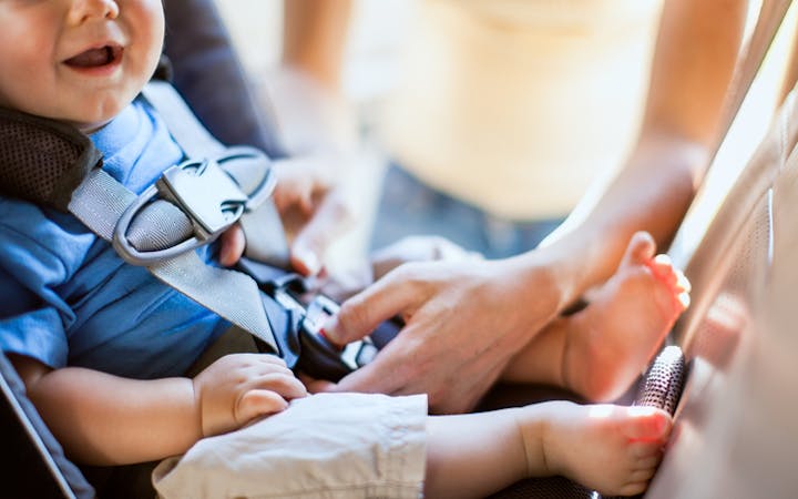 A photo shows a baby in a car seat.