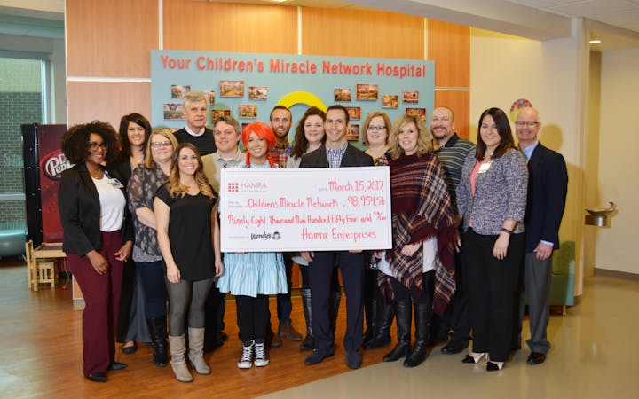 CMH and Hamra hold up a check of the donation.