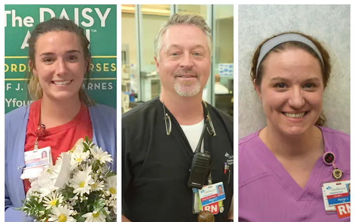 Three healthcare workers in scrubs; left holds a bouquet of daisies.
