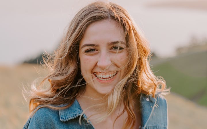 A young woman smiles broadly.