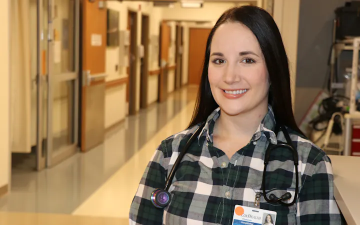Dr. Karissa Merritt, DO, in a hospital hallway with a stethoscope.