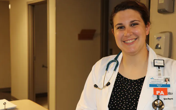 Erin Payne, PA, smiles in a white coat with stethoscope and CoxHealth badge.