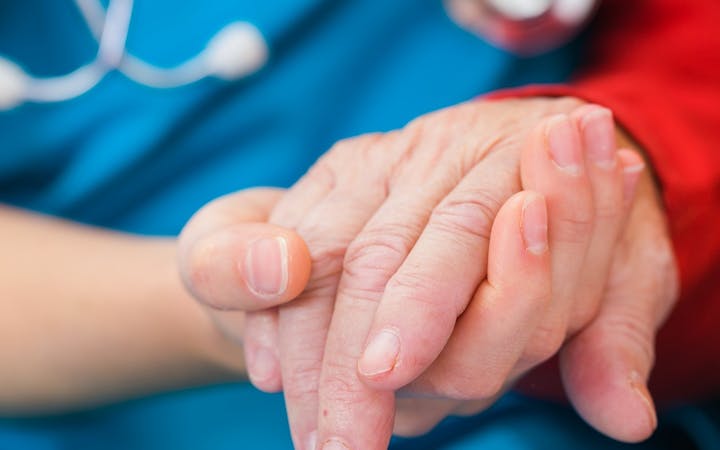 A nurse comforts a patient.