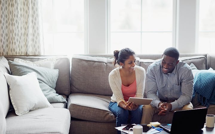 A couple looks at a computer screen.
