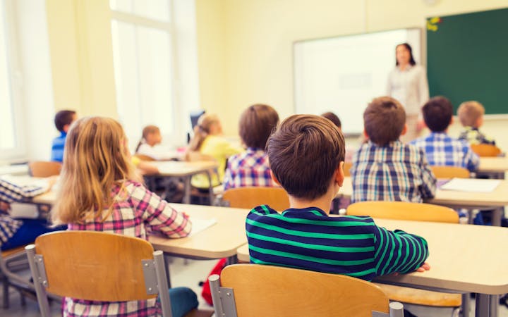 Children sit in a classroom.