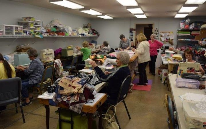 Group of women in a circle holding hands.