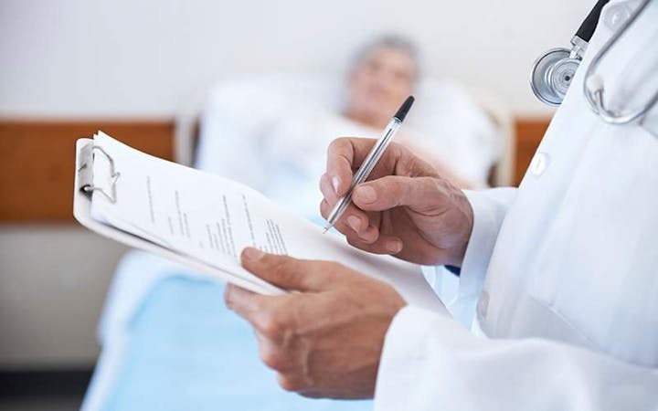 A doctor fills out paper work