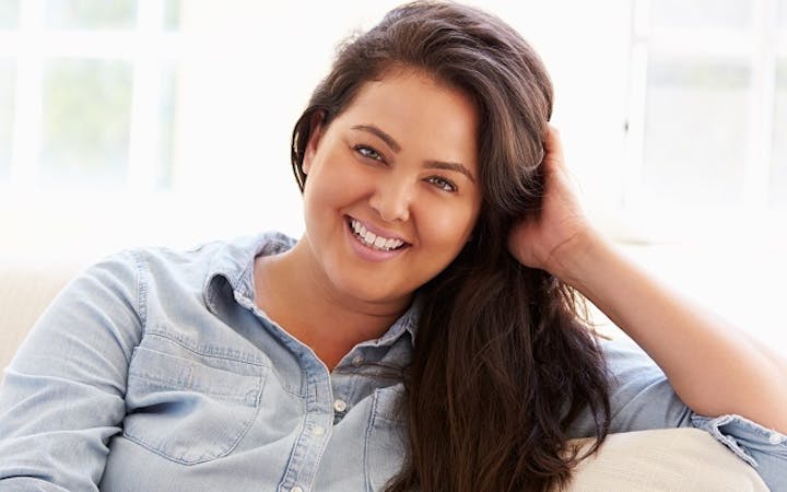 woman smiling while sitting on couch